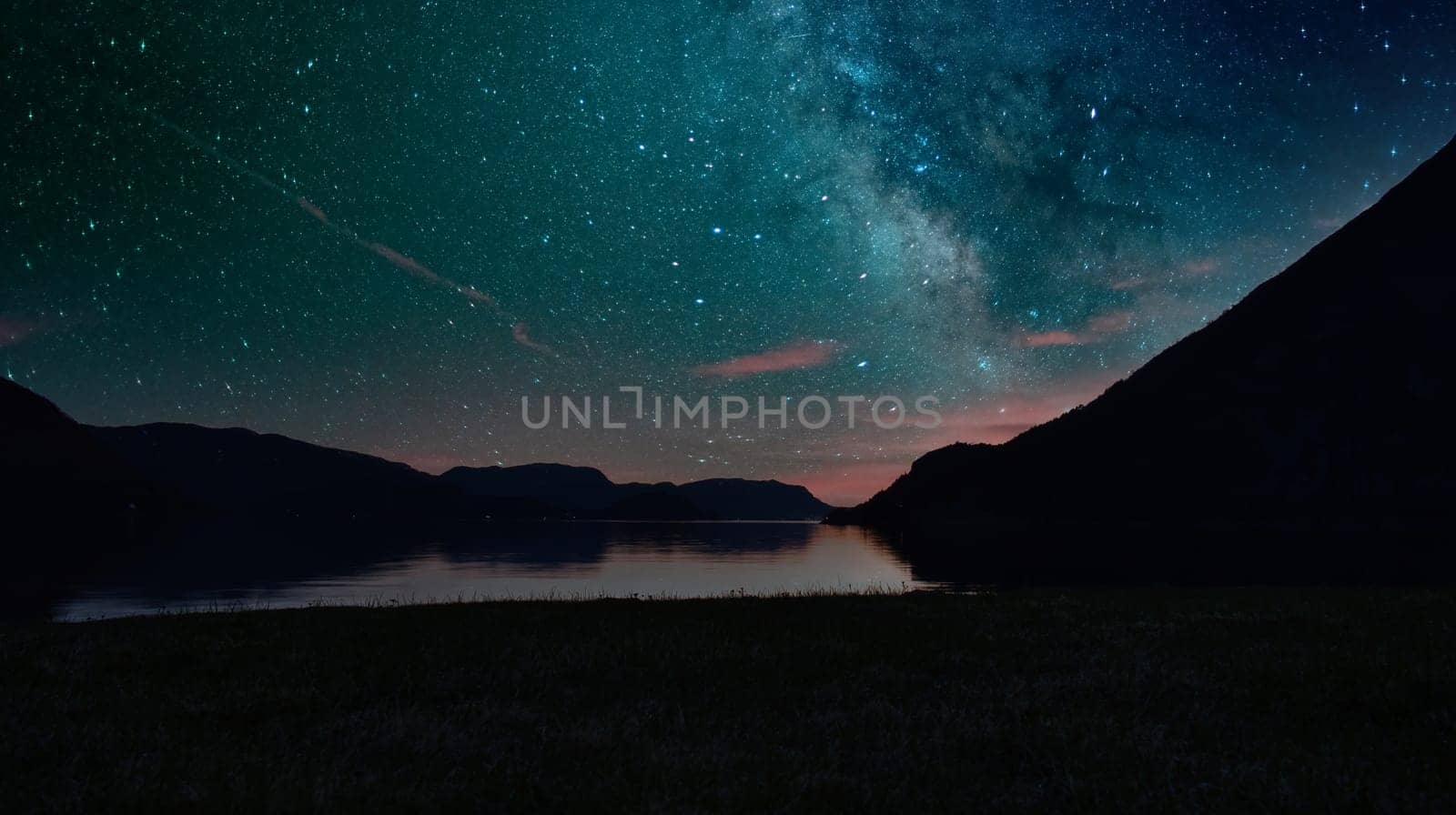 Fjord with Milky Way in the sky. View of mountains and fjord landscape in Norway. Landscape shot in the evening in the north