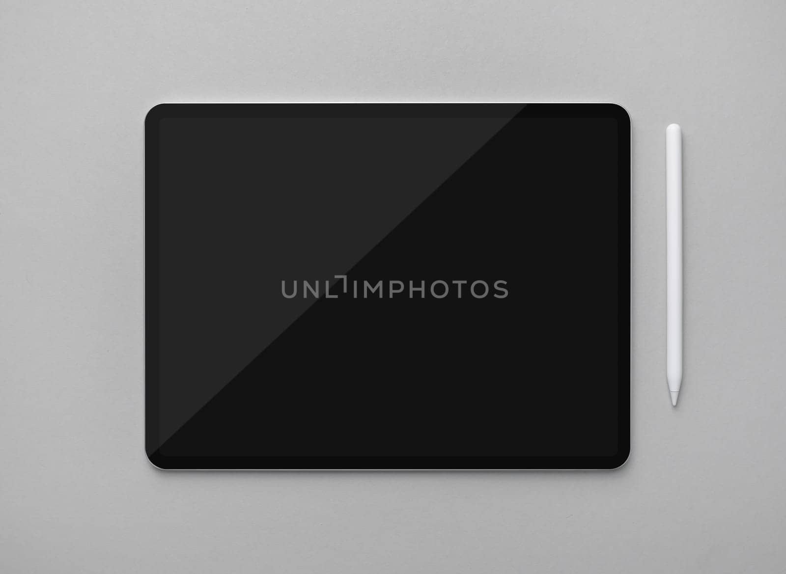Mockup of tablet computer with blank black screen and stylus on gray paper background. Top view. Flat lay.
