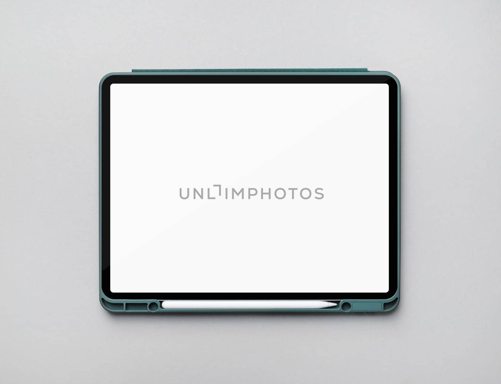Photo of modern touch tablet with blank white screen and stylus on gray paper background. Modern work tools of designer. Flat lay.