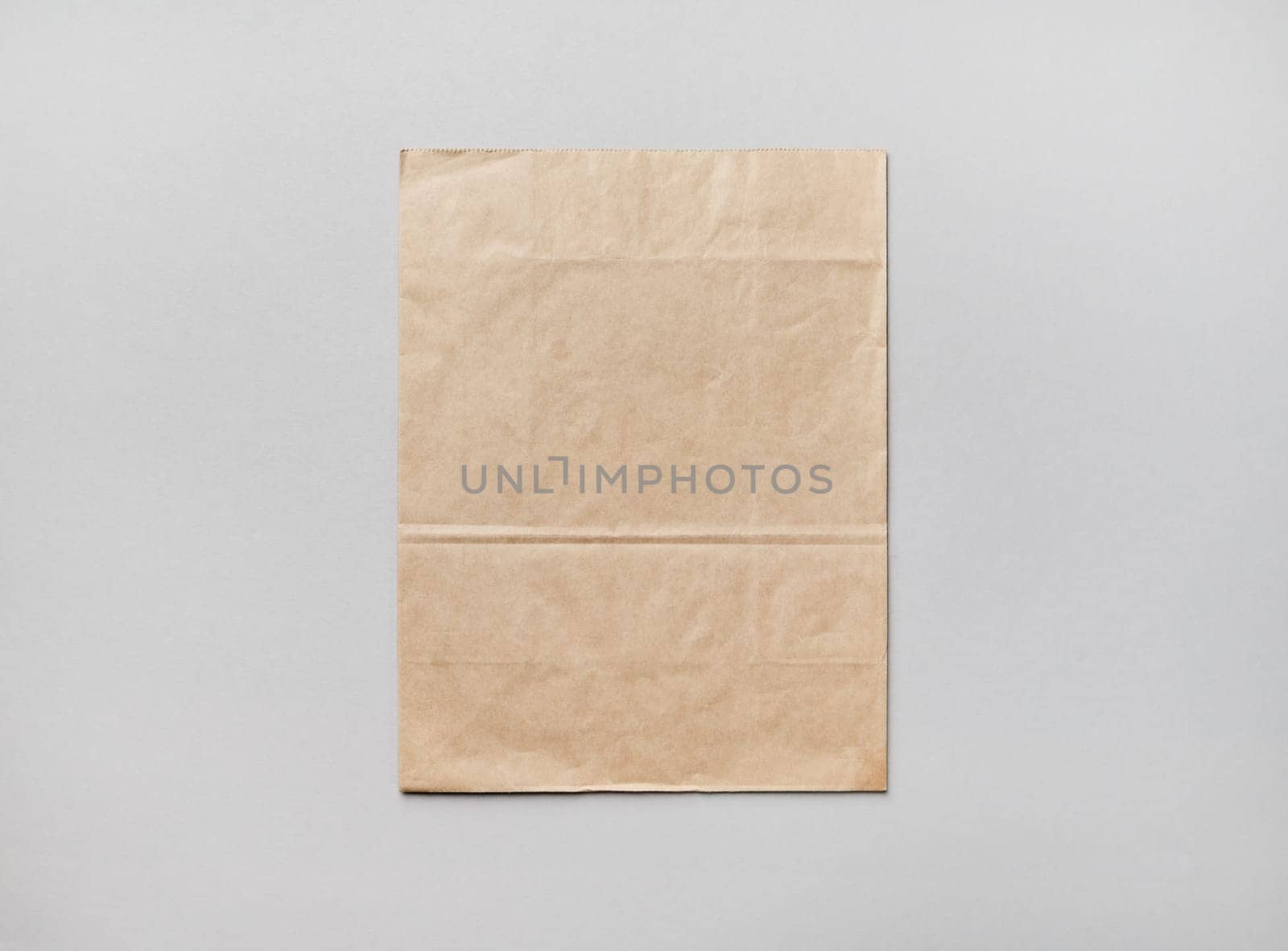Blank kraft paper pack on gray paper background. Responsive design mockup. Flat lay.