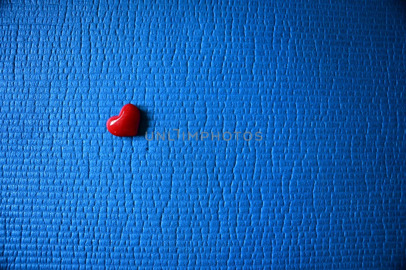 red heart lying on a blue ground