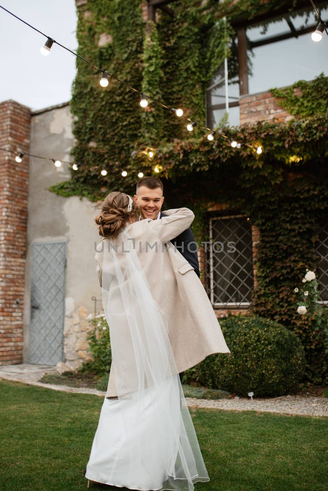 the first wedding dance of the bride and groom inside the restaurant hall in sunset light