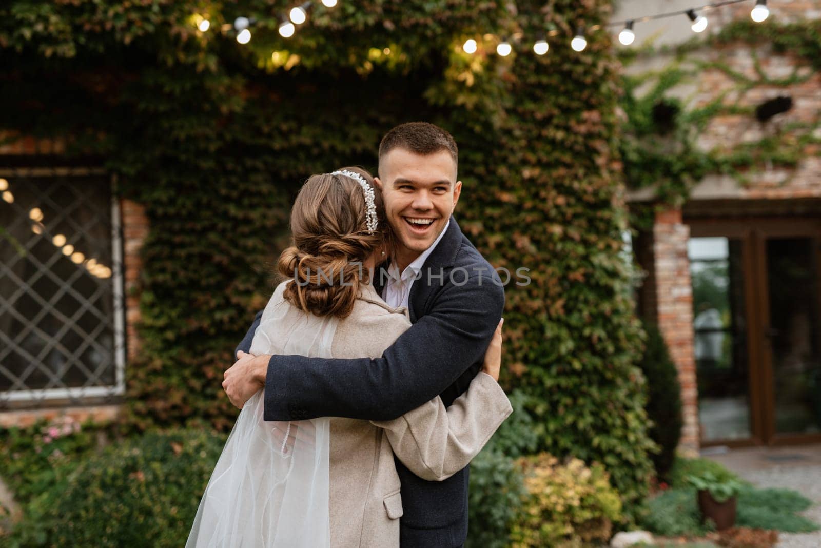 the first wedding dance of the bride and groom inside the restaurant hall in sunset light