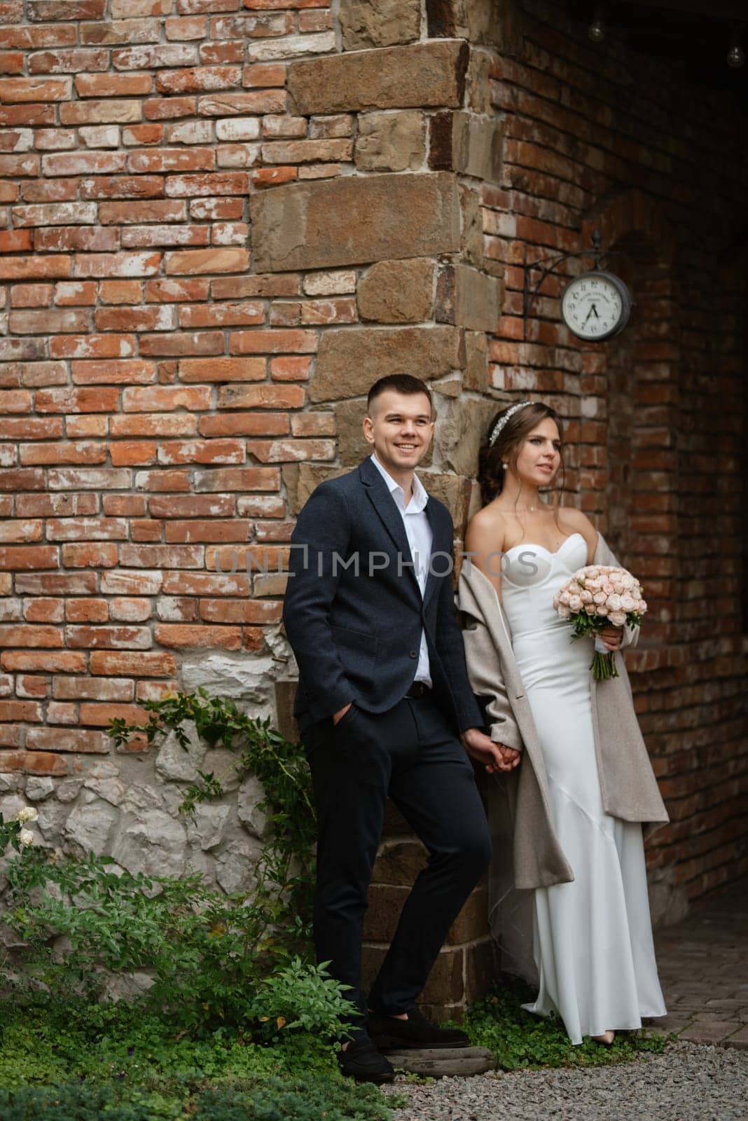 portrait of a young couple of bride and groom on their wedding day in a country cottage
