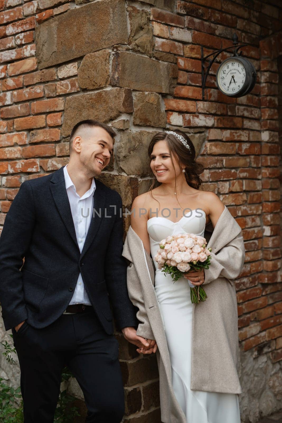 portrait of a young couple of bride and groom on their wedding day in a country cottage