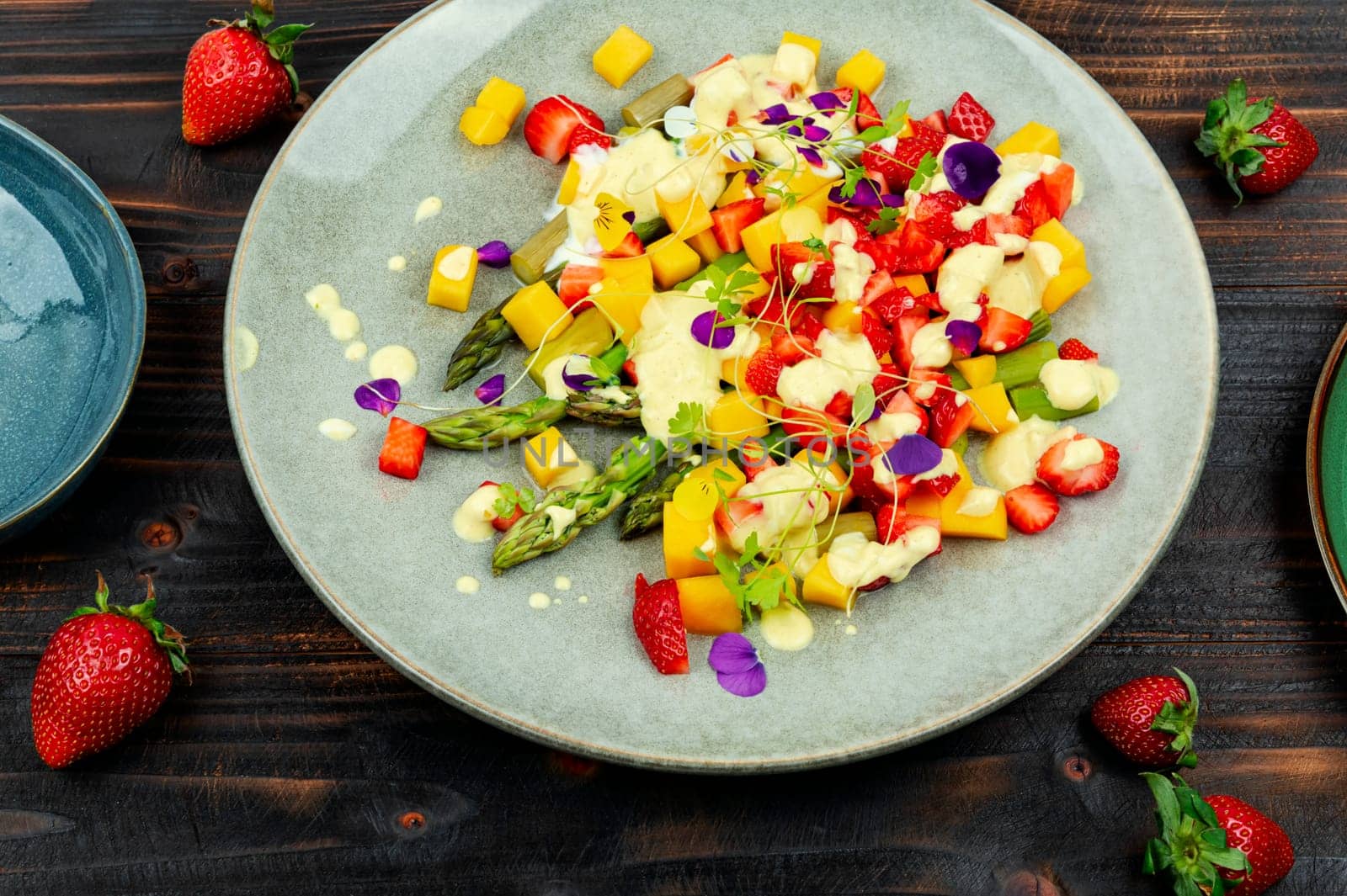 Light spring salad of berries, green asparagus, mango and yogurt. Copy space. Banner.