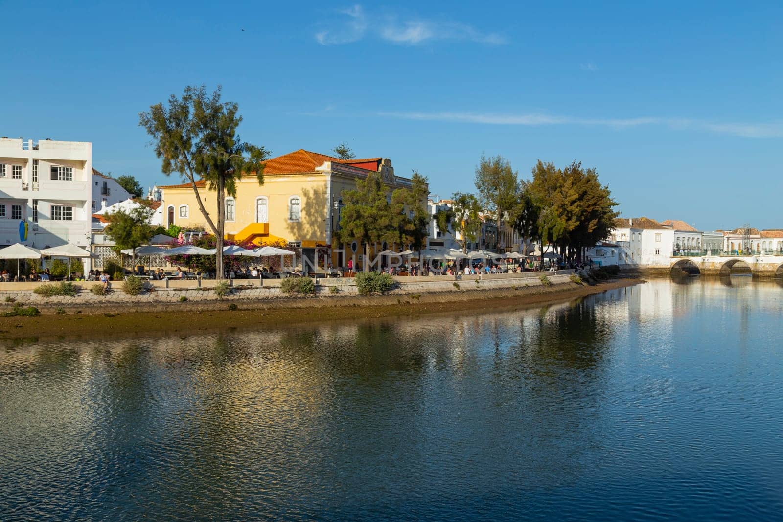 AVIRA, PORTUGAL - April 17, 2022 - Waterfront townhouses along the riverbank of the Gilao river with steps leading to the water, Tavira, Algarve, Portugal