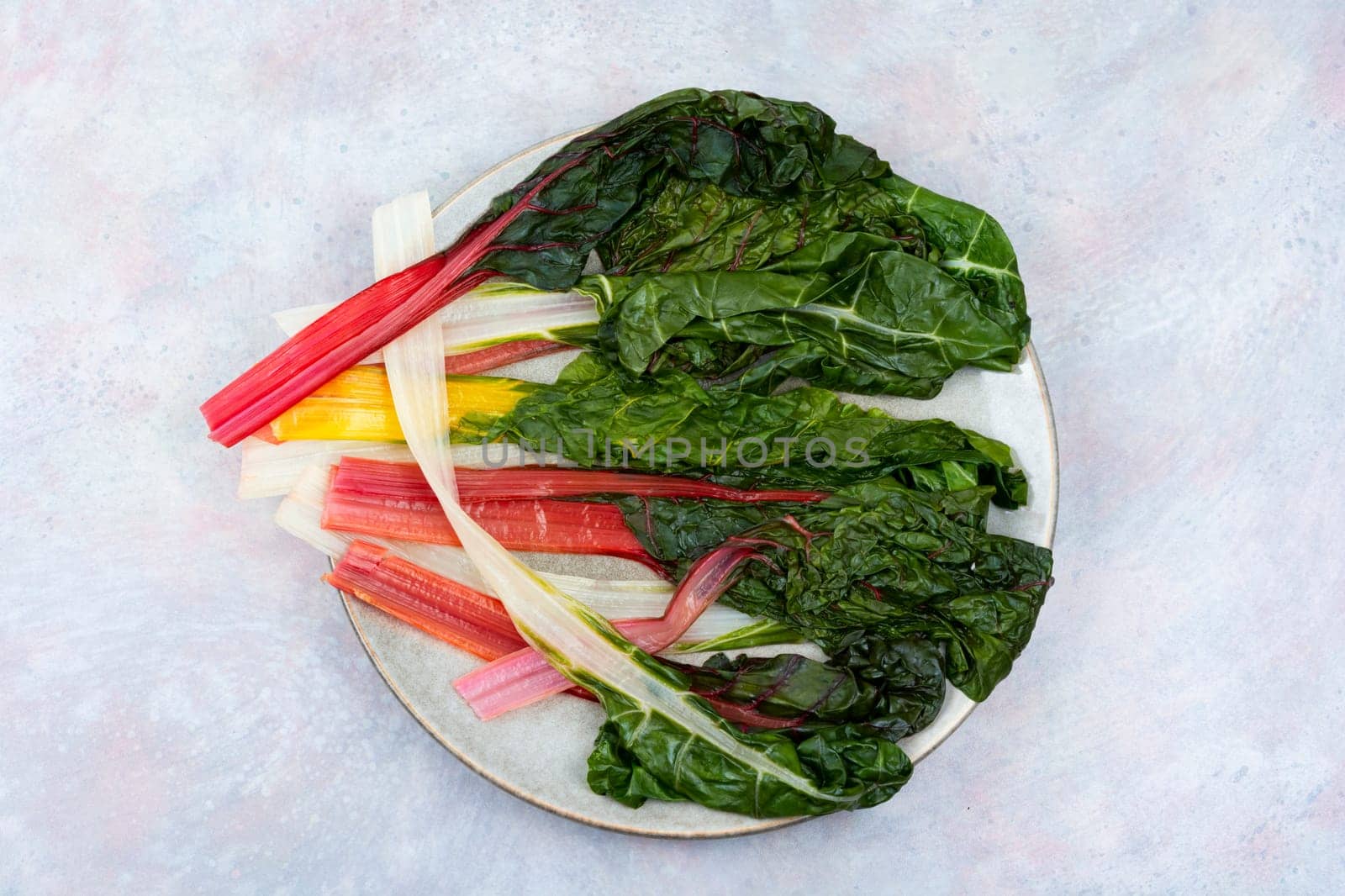 Tasty stewed colorful chard on a plate. Sauteed swiss chard. Close up