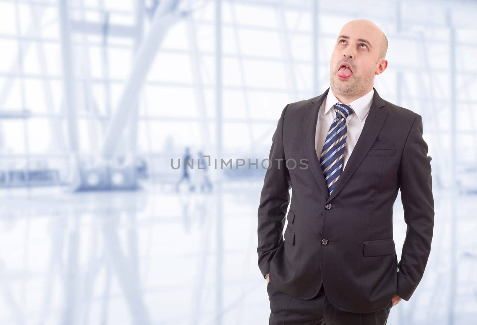 tired businessman in a suit looking up, at the office