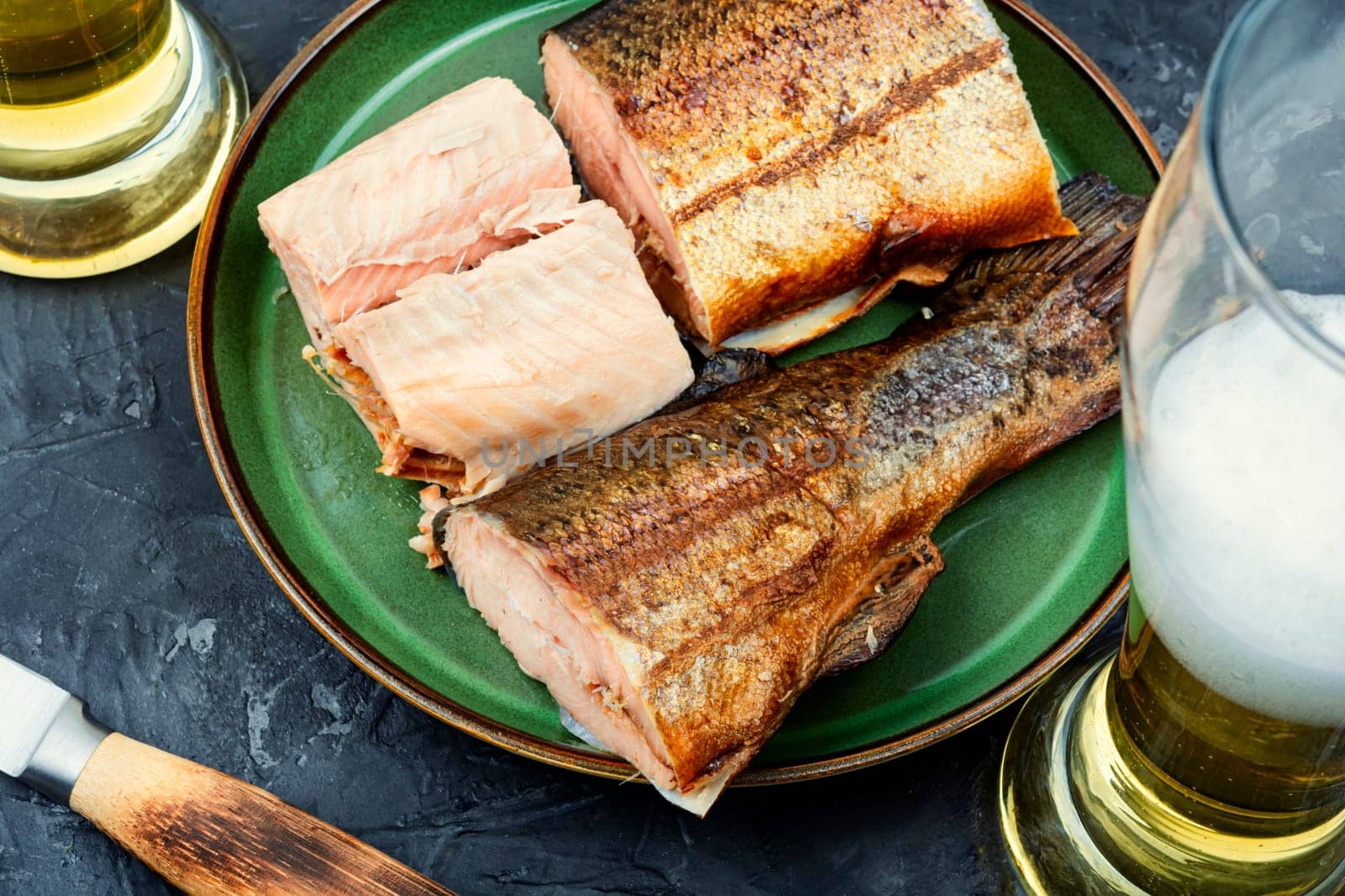 Tasty hot smoked trout salmon with beer