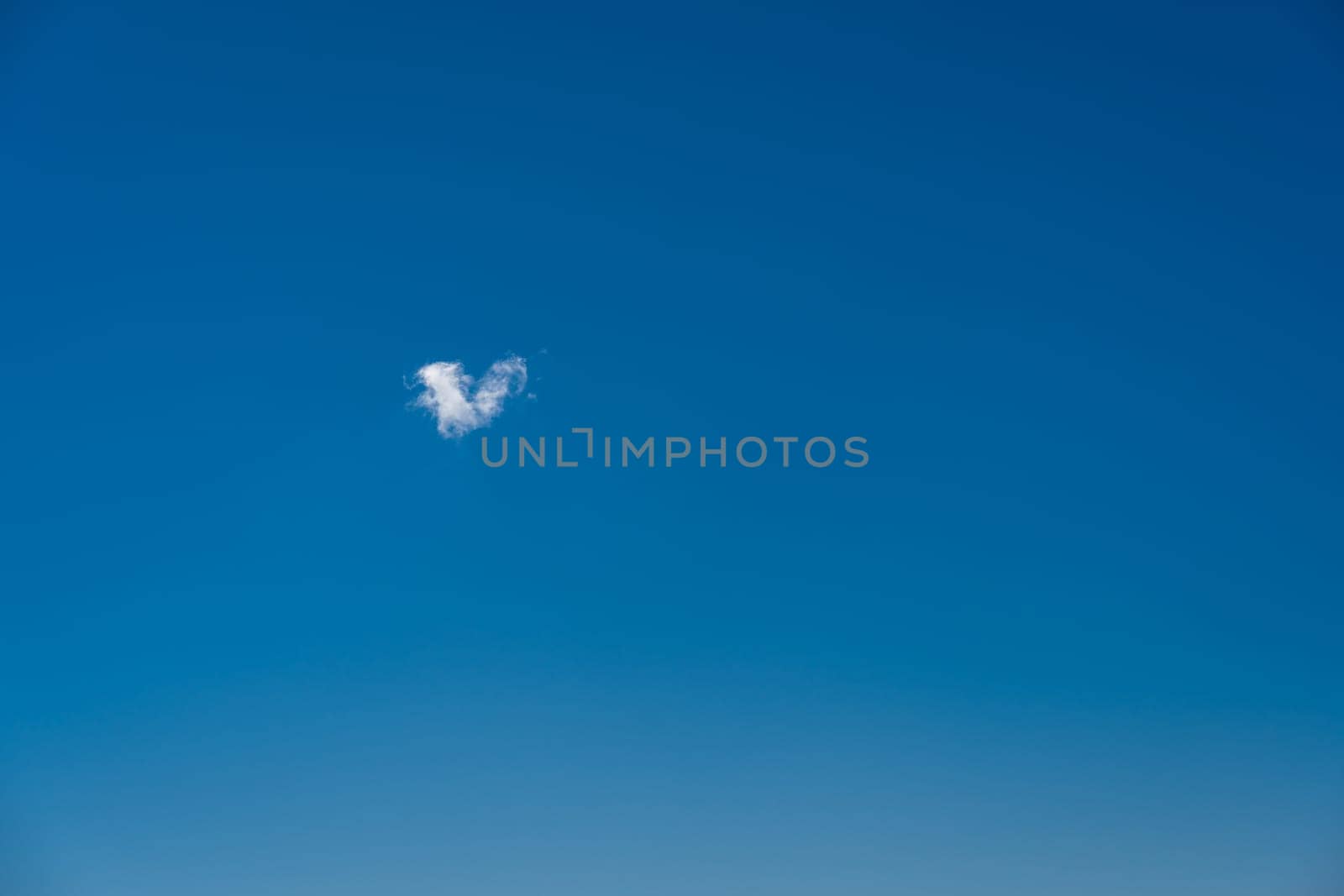 heart shaped cloud in the blue sky.