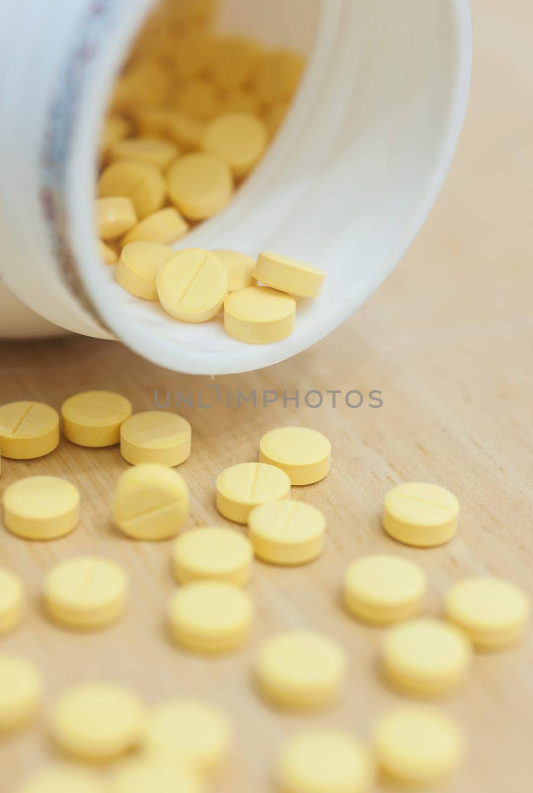 Medicine spilling out of a bottle on wood table