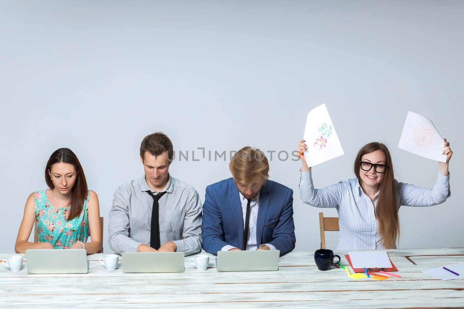 Business team working together at office on light gray background. all working on laptops. boss enjoying a good idea. copyspace image