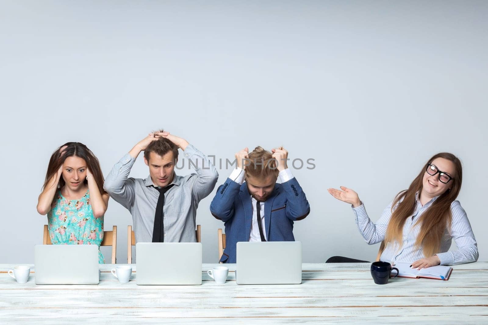 Business team working on their business project together at office on light gray background. all all grabbed his head. boss laughing. copyspace image.