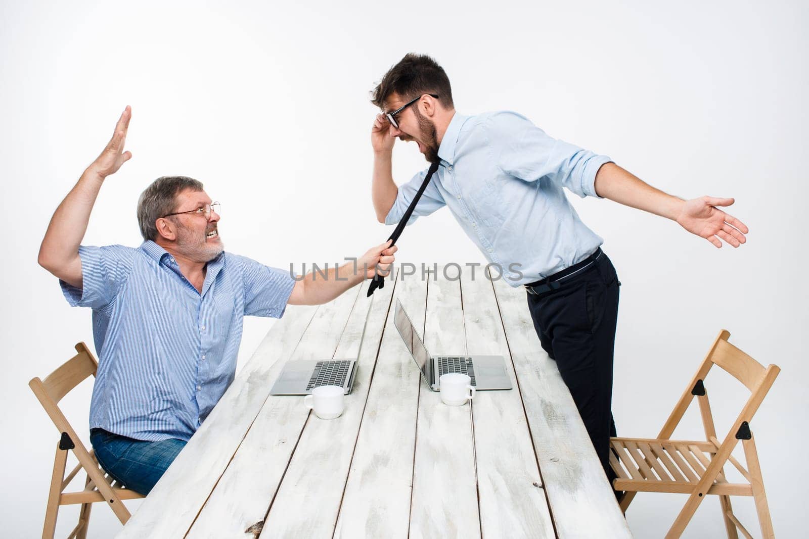 Business conflict. The two men expressing negativity while one man grabbing the necktie of her opponent on white background
