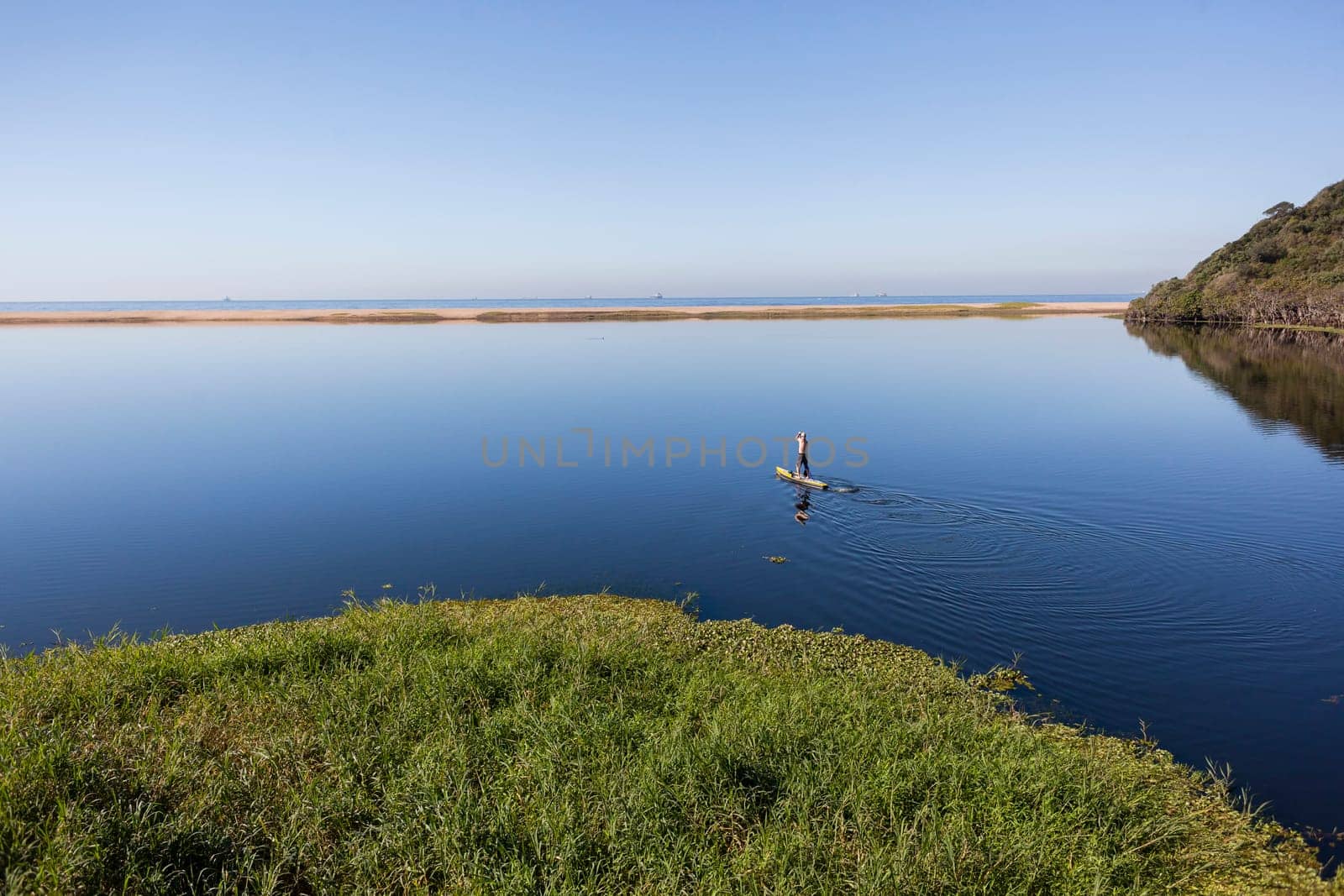 Blue lagoon rural river water paddler board  coastline scenic landscape