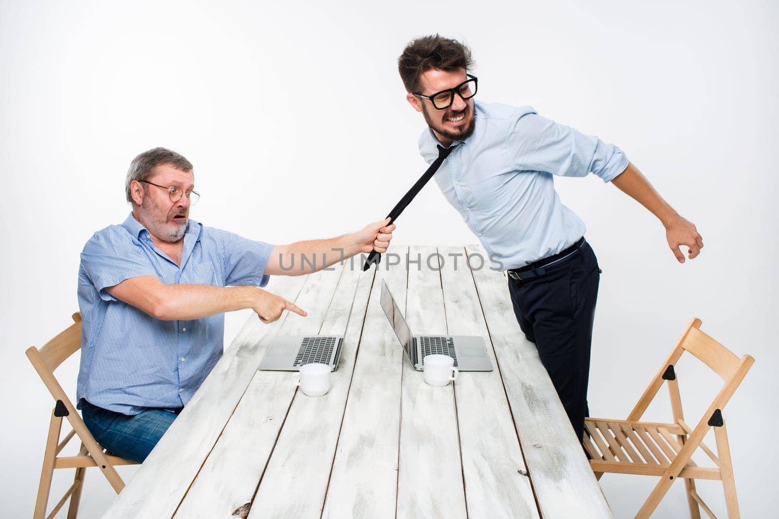 Business conflict. The two men expressing negativity while one man grabbing the necktie of her opponent on white background