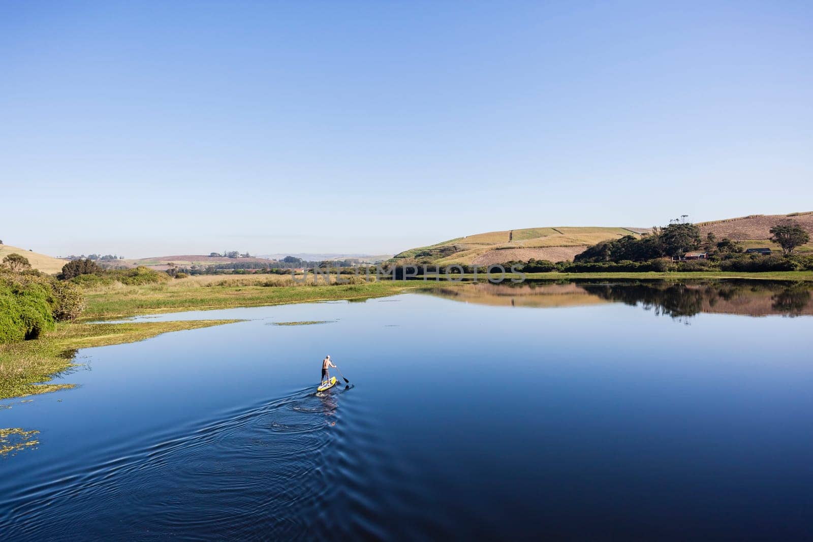 Blue lagoon rural river water paddler board  coastline scenic landscape