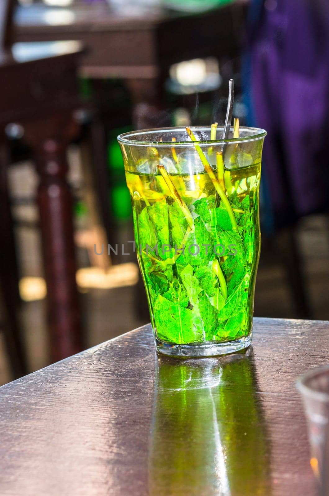 Glass filled with beautiful fresh green peppermint tea leaves.