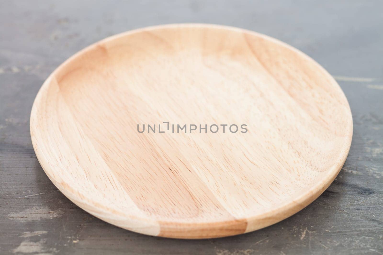 Wooden plate on gray background, stock photo