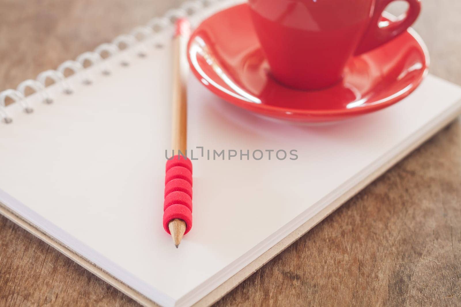 Red mug with open notebook, stock photo