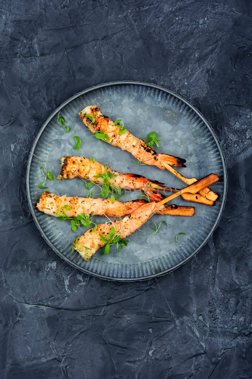 Tasty shrimp barbecue with herbs fried on wooden sticks. Prawns skewers. Space for text