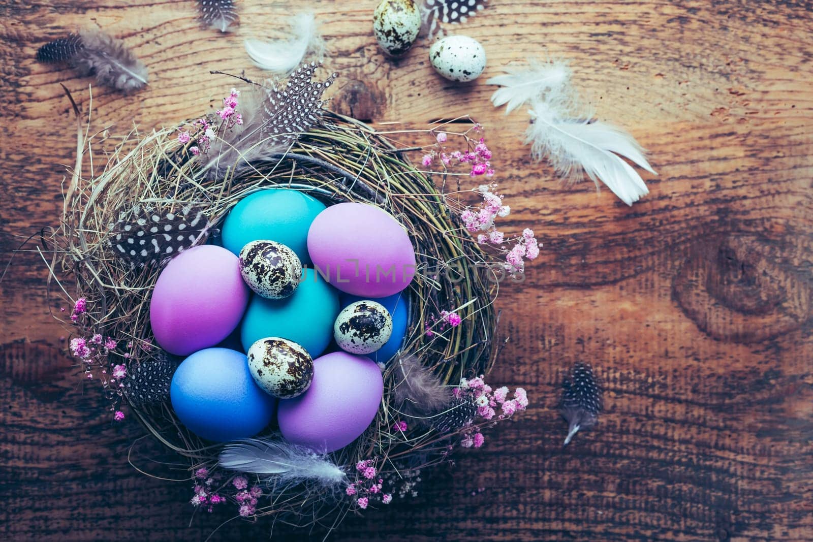 Happy Easter - nest with Easter eggs on wooden background with copy space