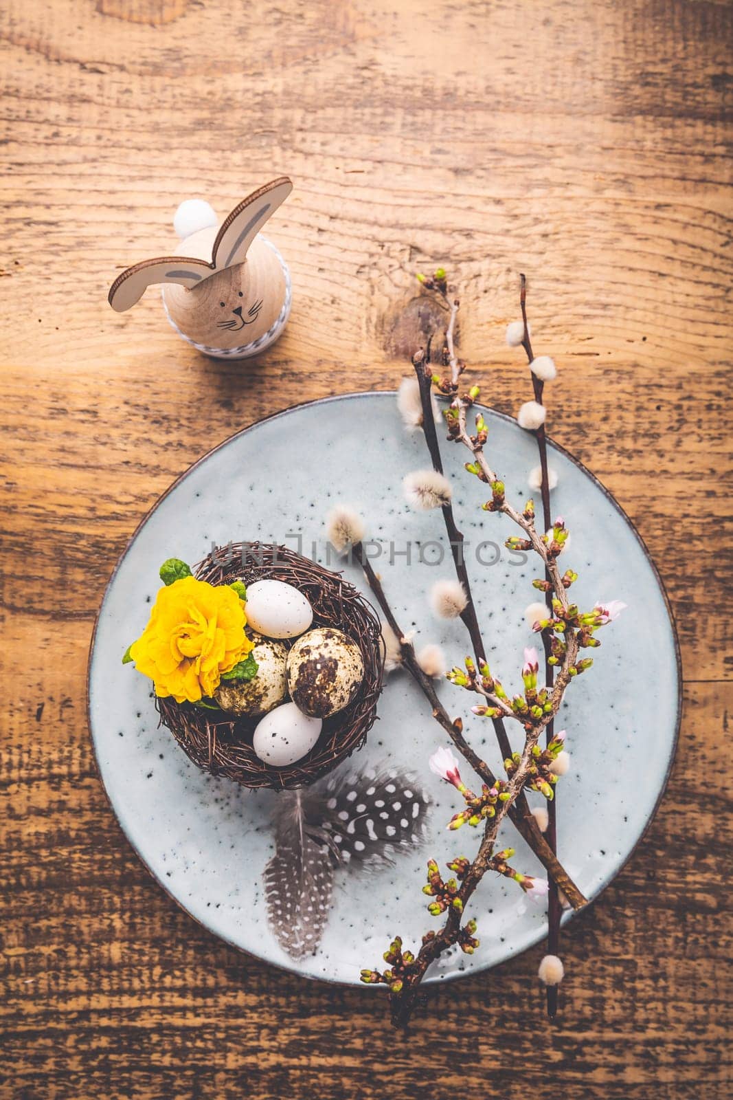 Easter table setting with spring flowers and cutlery on wooden table. Spring Easter Holiday Table
