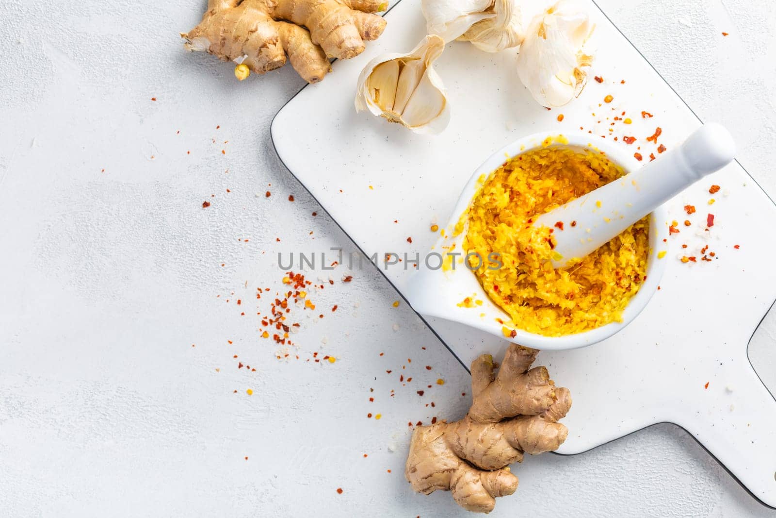 Homemade Fresh Ginger and Garlic paste or Adrak Lahsun puree in ceramic bowl on white background. Asian cuisine