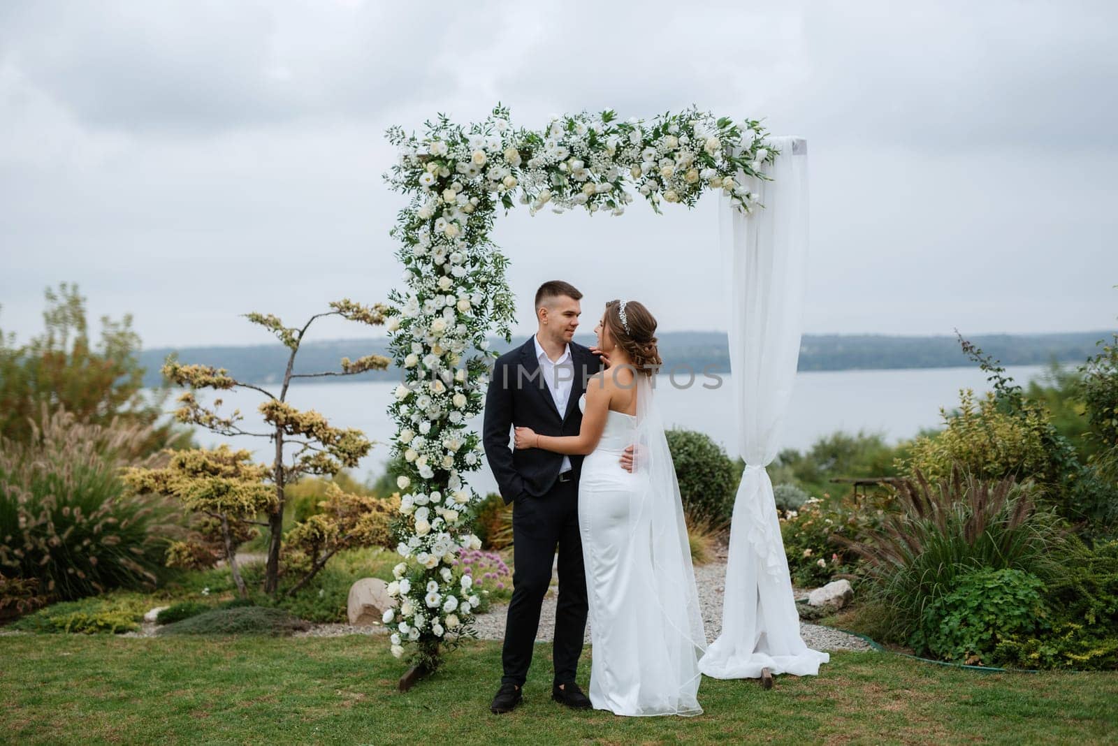 wedding ceremony of the newlyweds in a country cottage on a green hill