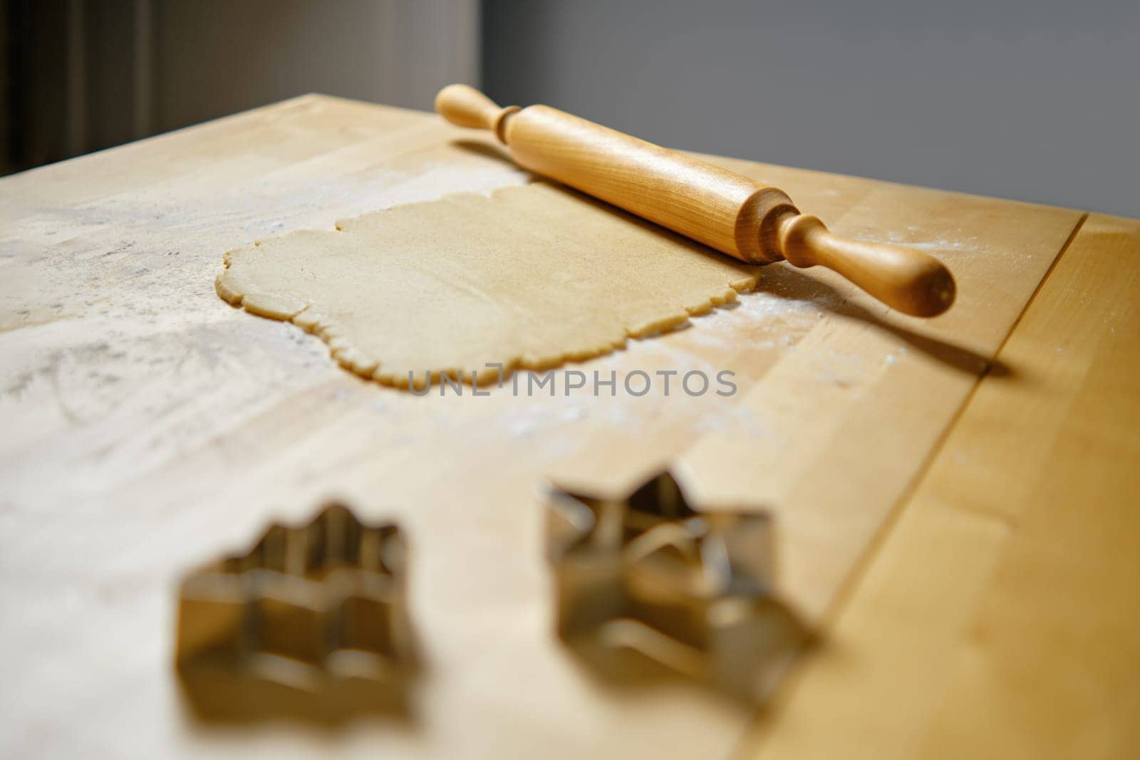 Flat ginger dough on the kitchen table and rolling pin (selective focus photo)
