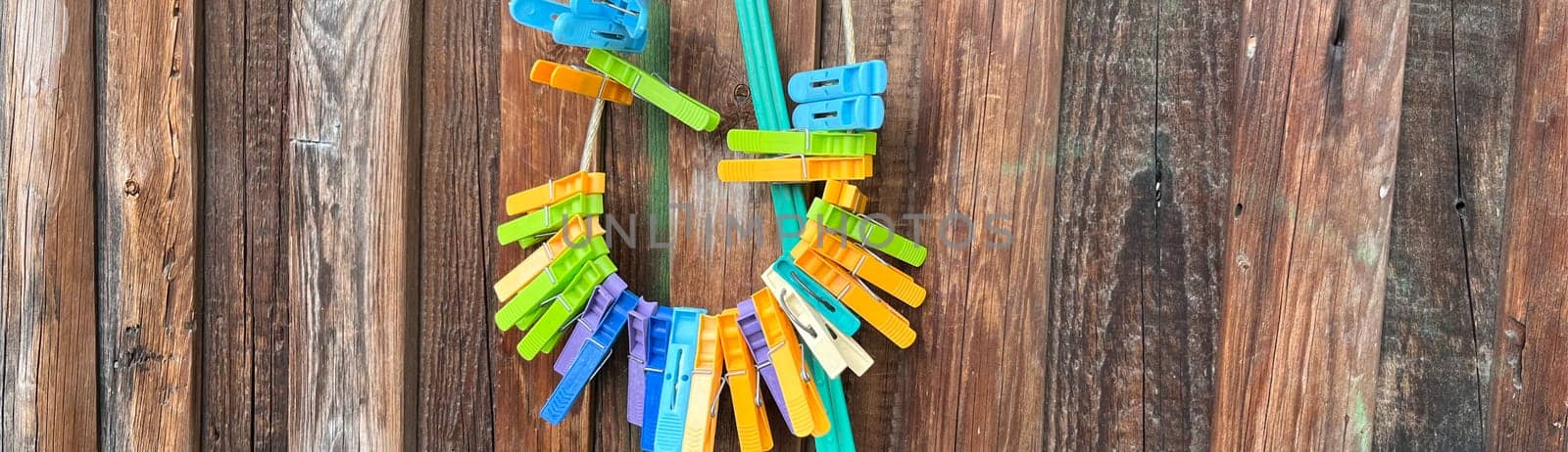 colorful clothespins hang on the wooden fence