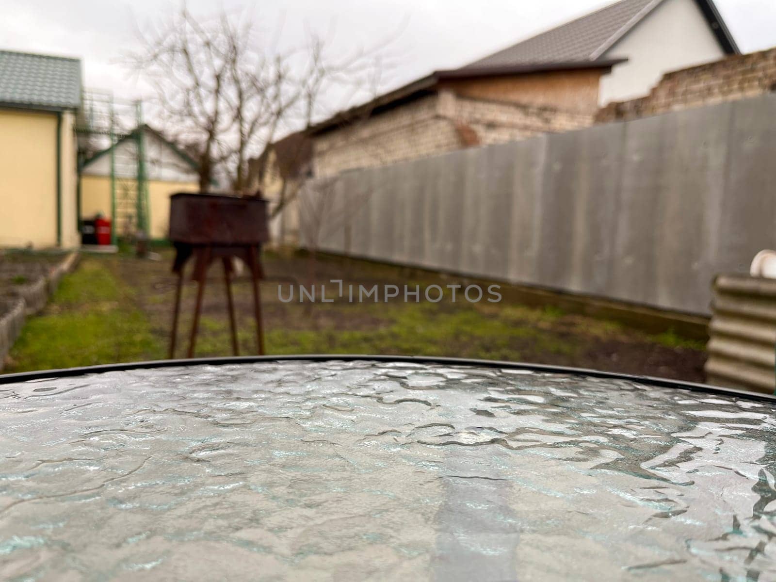 raindrops on a glass table in the garden in early spring