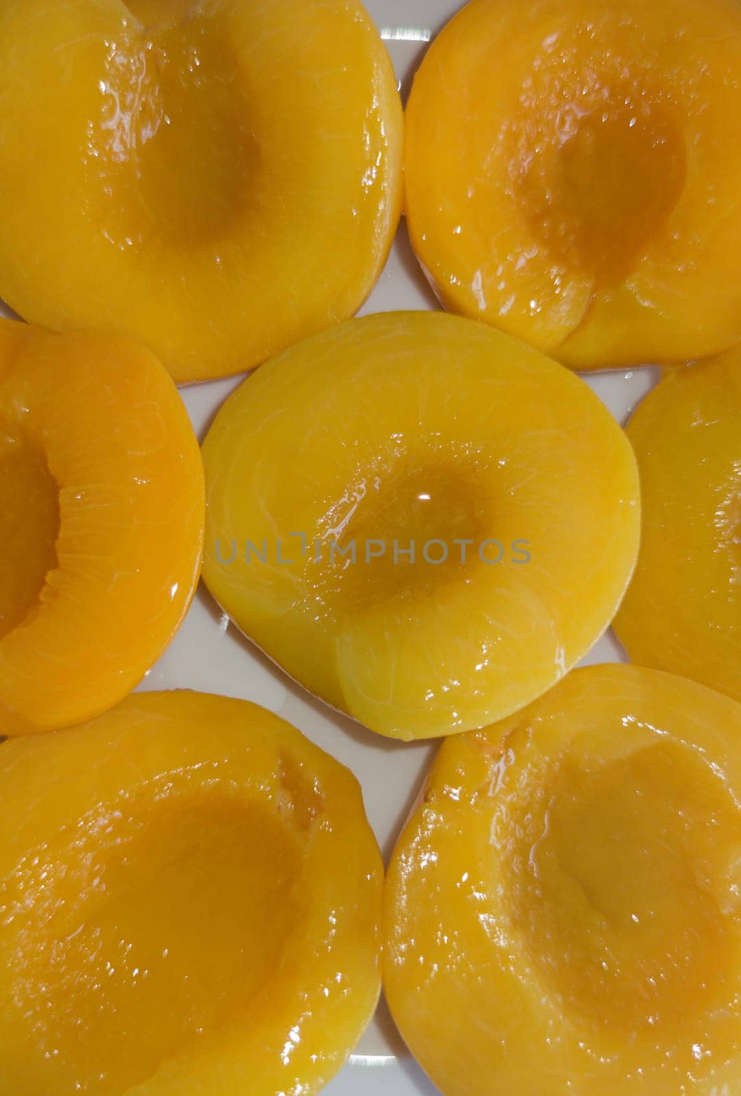 Plate of peaches halves in syrup. Overhead shot