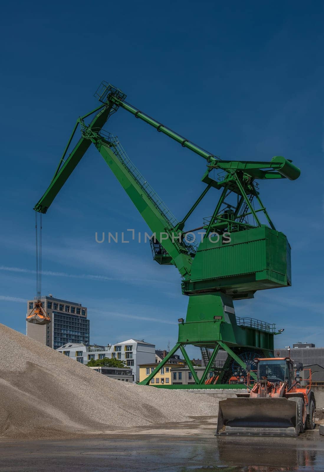 Exterior view of a cement factory with green crane