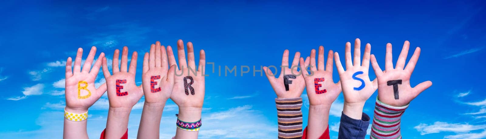 Children Hands Building Colorful English Word Beer Fest. Blue Sky As Background.