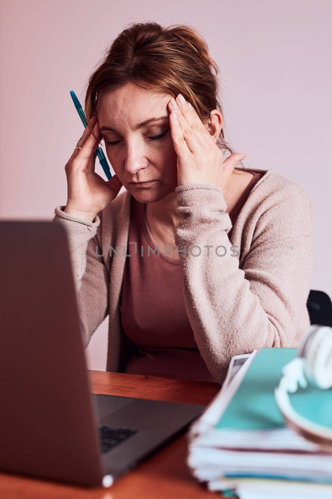 Woman focused on her work working hard doing her job remotely on laptop from home. Woman sitting at desk in front of computer looking at screen. Concept of remote working