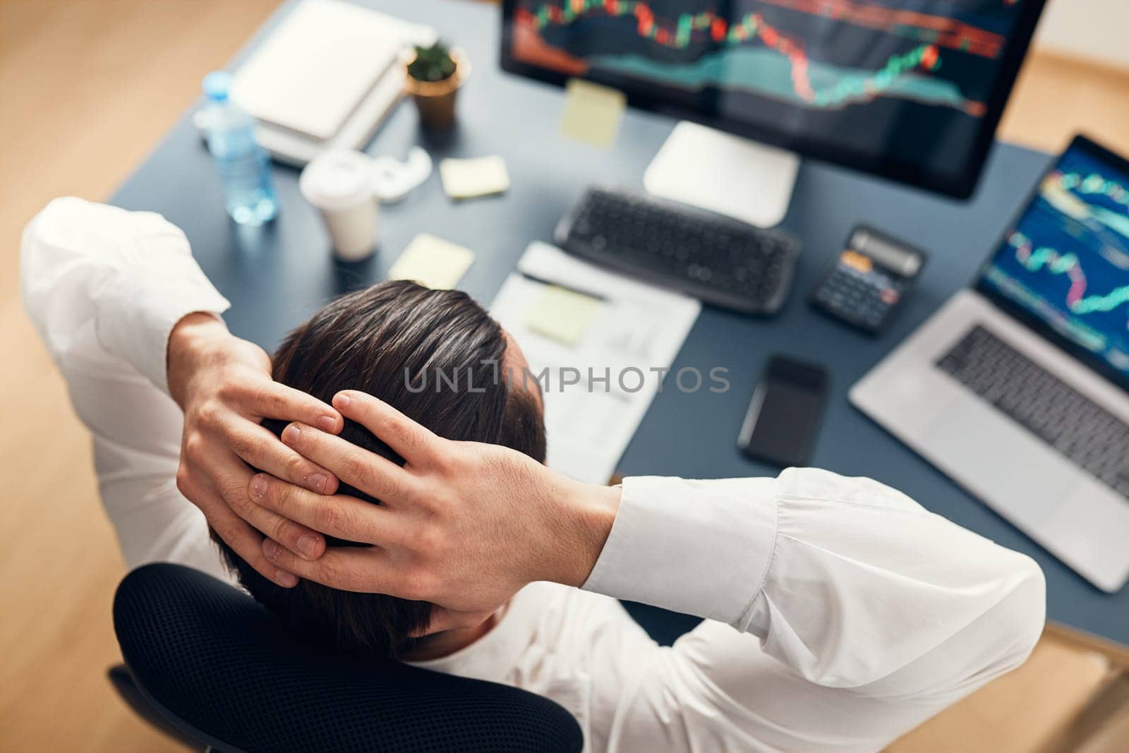 Worried businessman looking at charts stressed by news from stock market. Investor lost money online. Man analyses loss and profit. Businessman investing stocks online. Man working with stock chart data. Business investing trouble concept