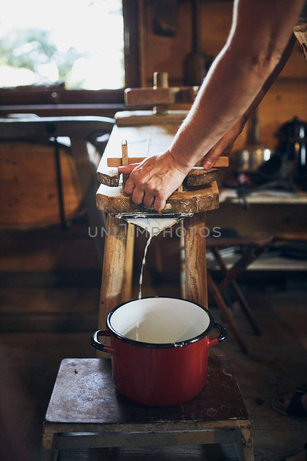 Cheese making. Person making cottage cheese using cheese press and traditional old technique. Old rustic kitchen