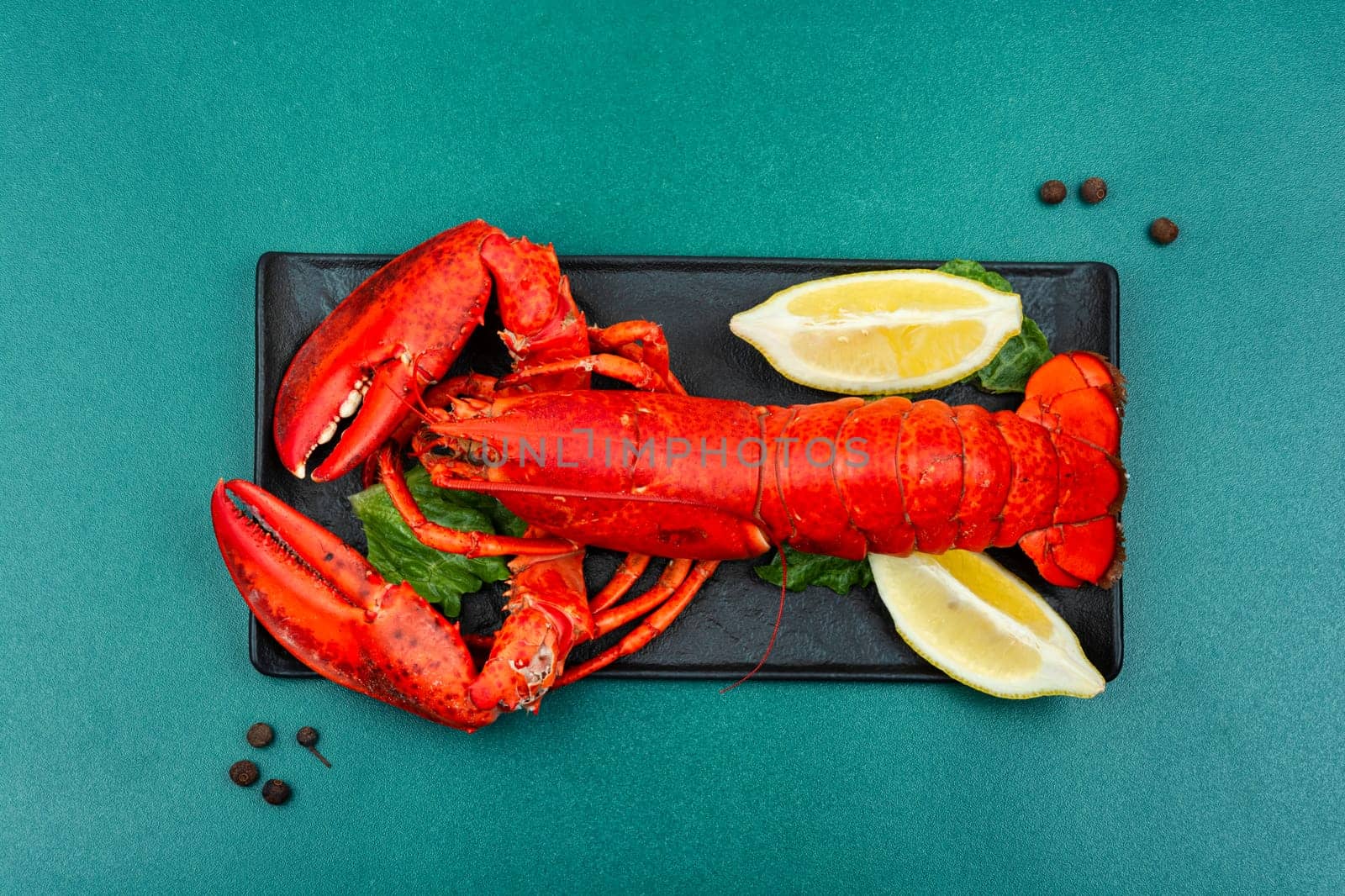 Boiled lobster with lemon on a tray. Expensive food. Seafood