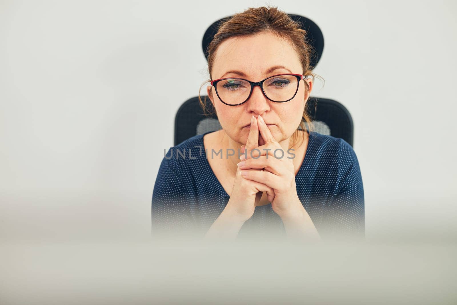 Woman entrepreneur focused on solving difficult work. Confused businesswoman thinking hard looking at computer screen sitting at her desk in office
