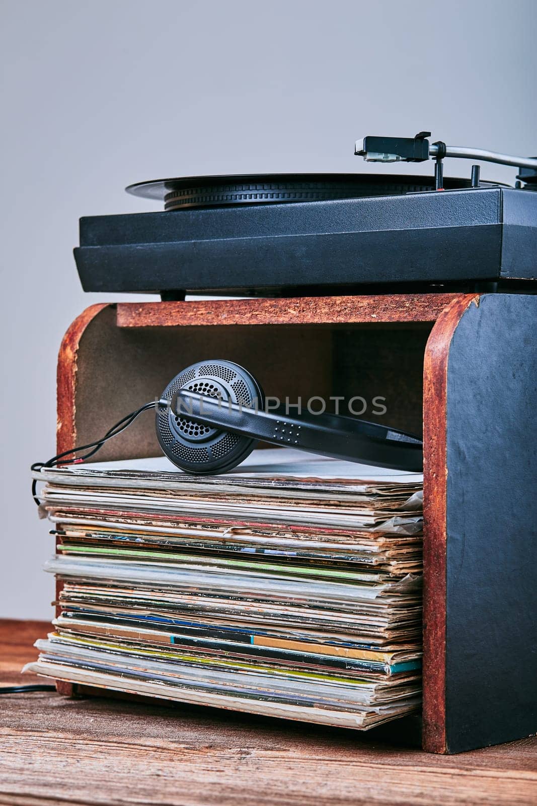 Stack of black vinyl records, turntable vinyl player and headphones. Classic stereo set. Candid people, real moments, authentic situations