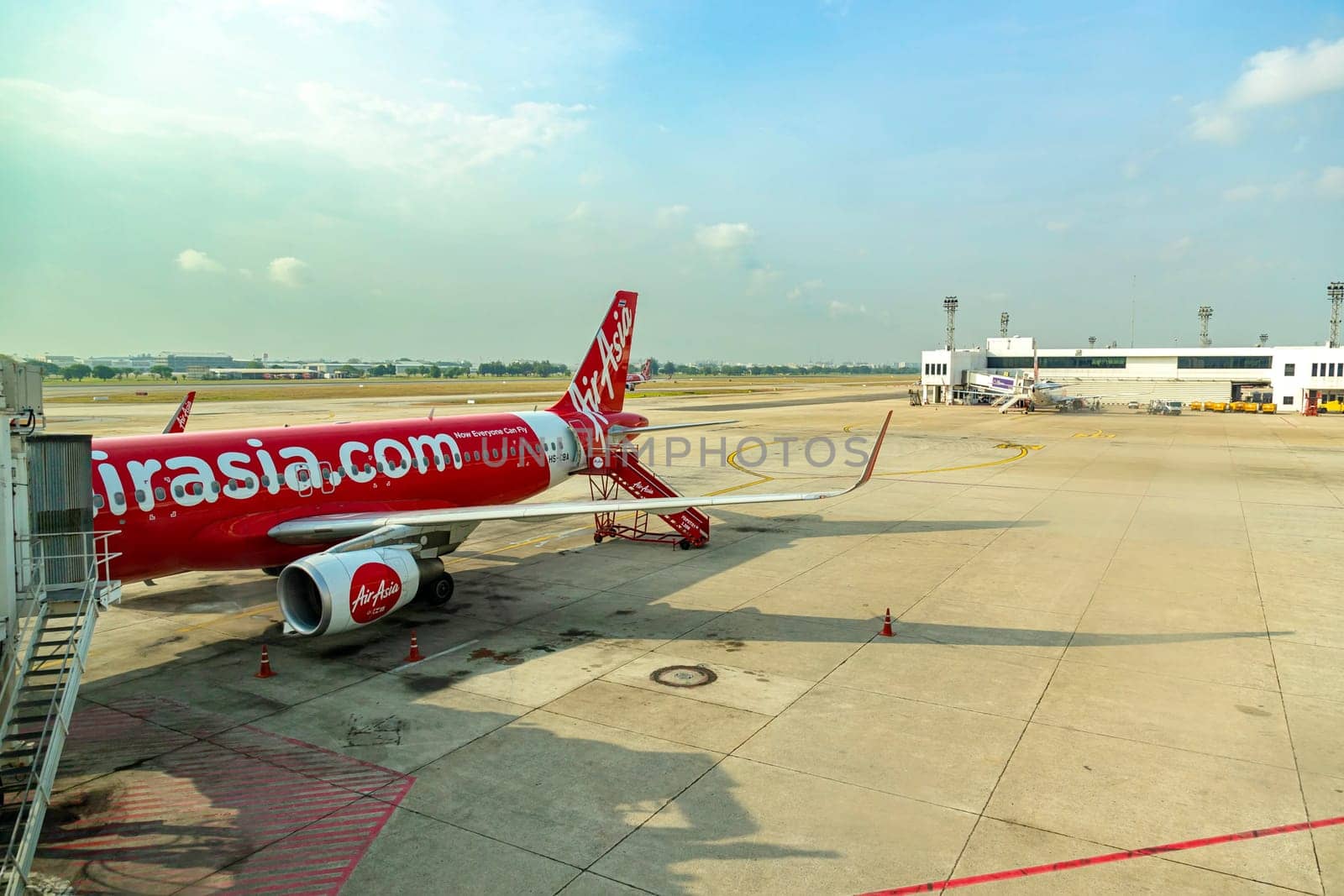 Bangkok Thailand - March 28, 2019: AirAsia's airplane, a popular low-cost airline in Thailand, is parked at Don Mueang International Airport, ready to transport passengers on a clear and sunny day.