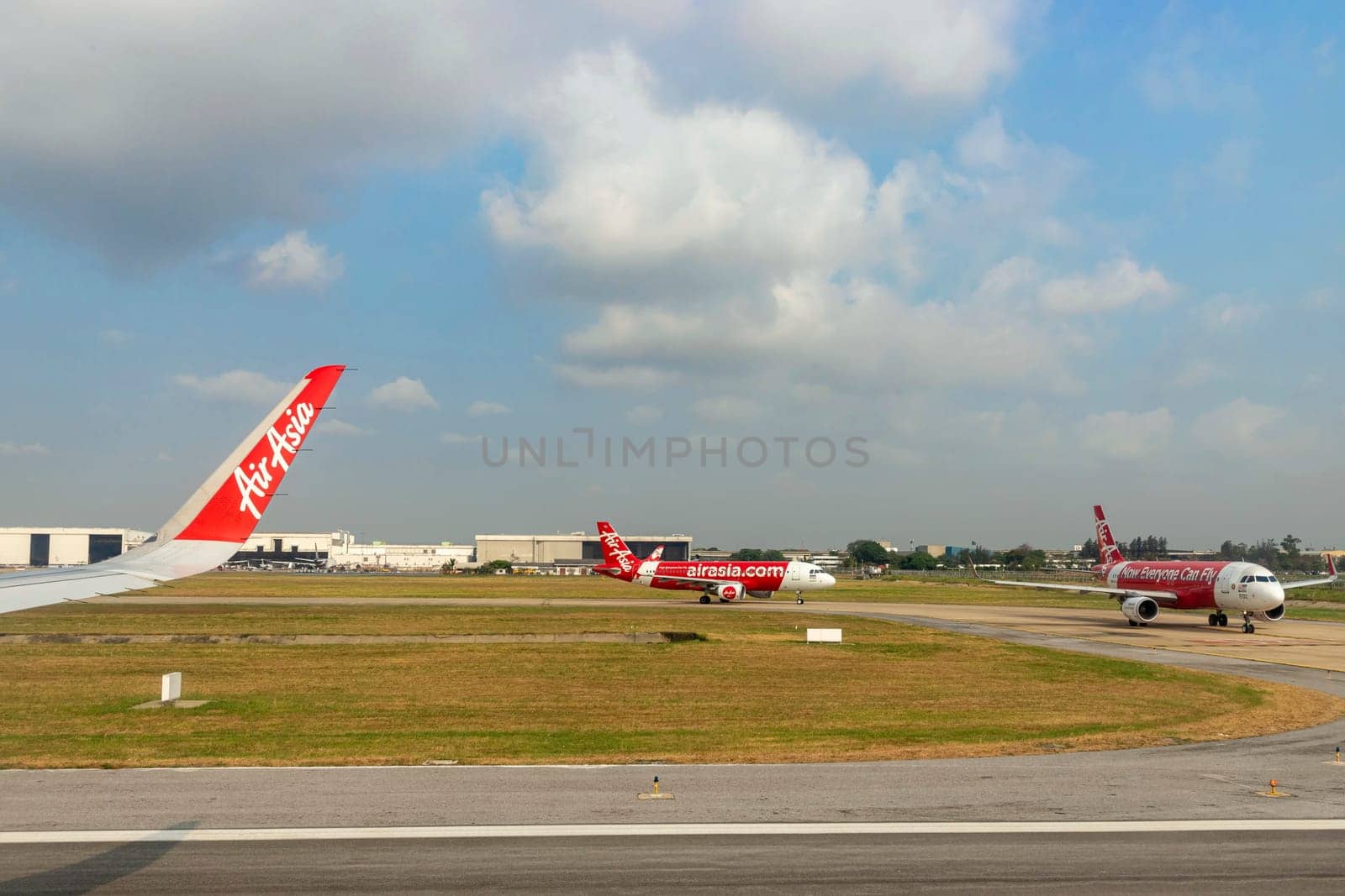 Bangkok Thailand - Mar 28, 2019: AirAsia (Budget airline that is highly popular in Thailand)'s airplanes are currently taxiing on the runway at Don Mueang International Airport, preparing for takeoff.
