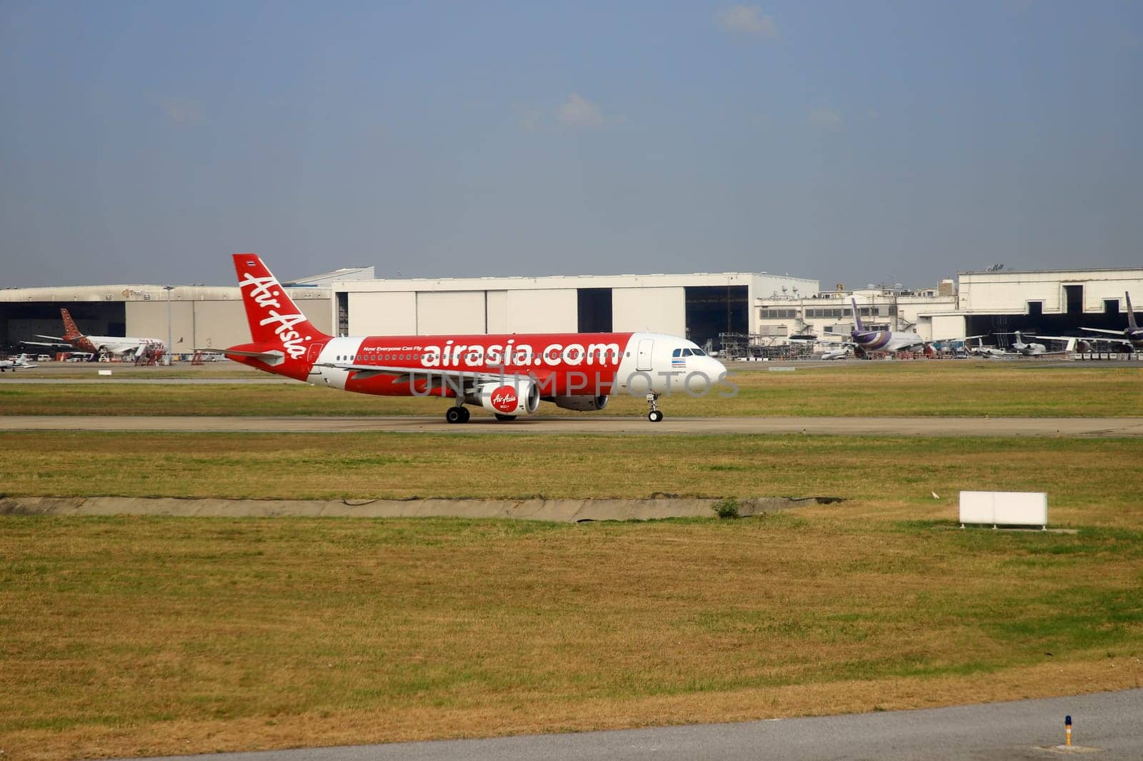 Bangkok Thailand - Mar 28, 2019: AirAsia (Budget airline that is highly popular in Thailand)'s airplanes are currently taxiing on the runway at Don Mueang International Airport, preparing for takeoff.