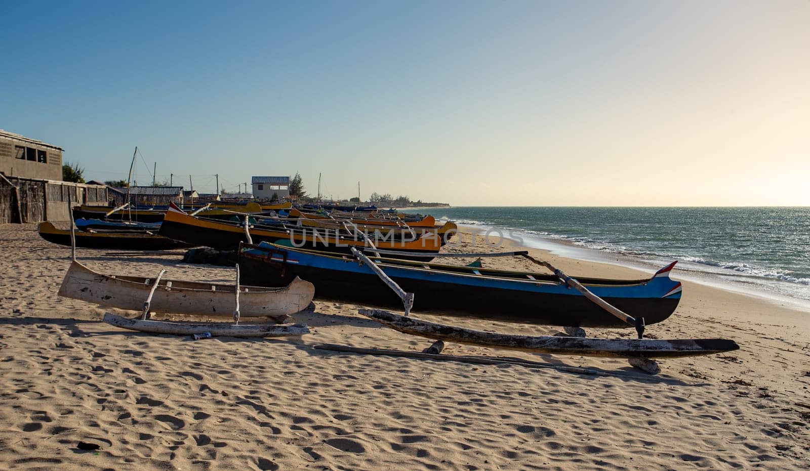 An empty wooden traditional fishing boat on the shore, waiting for the next catch of the day in Madagascar. Traditional wooden fishing boats on the tropical beach of Anakao, Toliara, Madagascar.