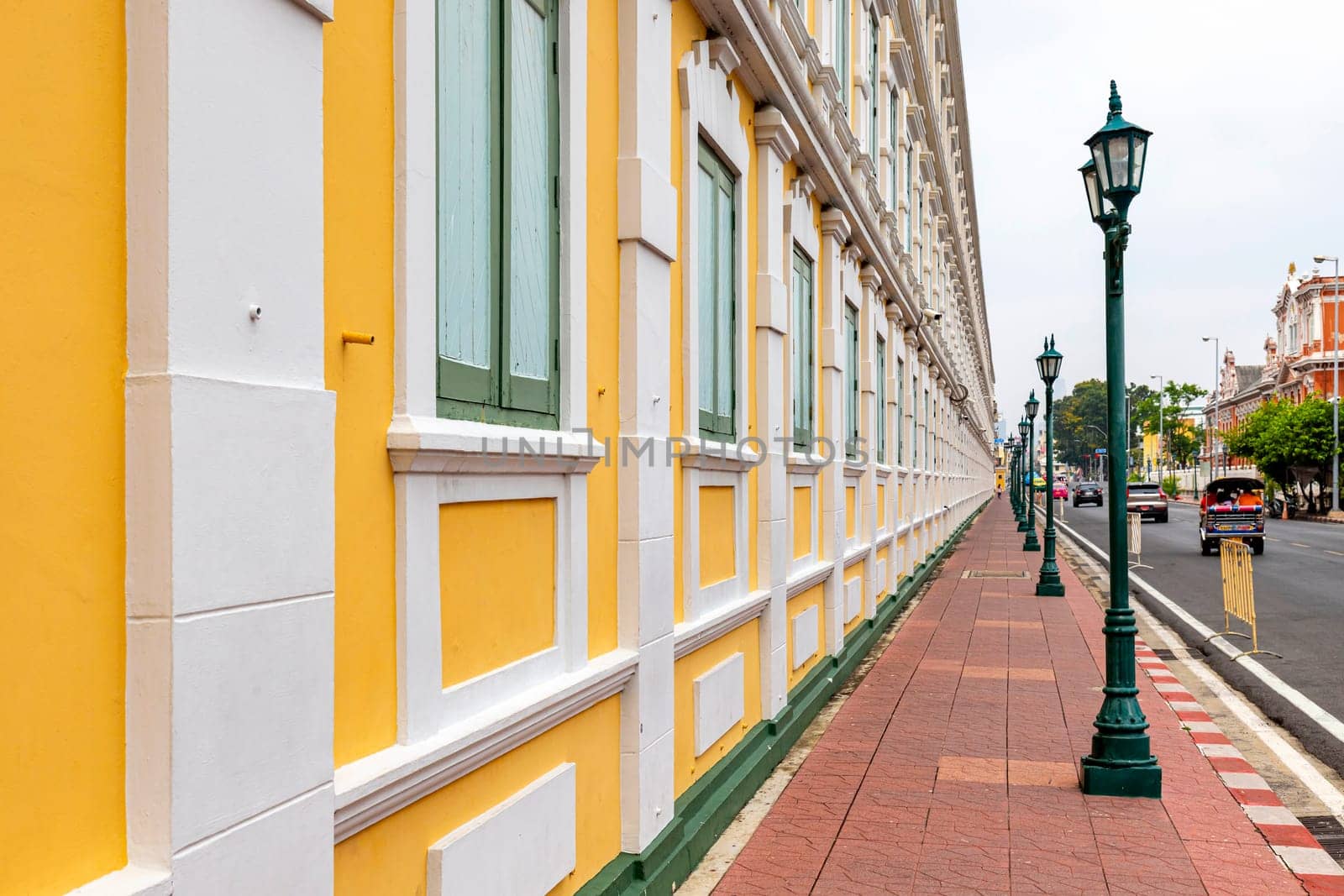 Bangkok,Thailand - April 16, 2023: The yellow building contrasts with the white stripes and has light green windows of Thailand's Ministry of Defense. A popular spot for tourists to take pictures.