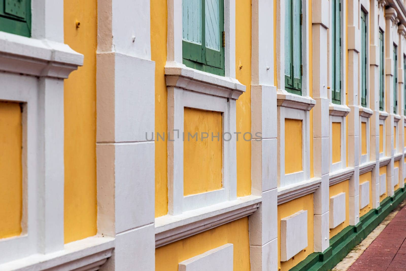 Bangkok,Thailand - April 16, 2023: The yellow building contrasts with the white stripes and has light green windows of Thailand's Ministry of Defense. A popular spot for tourists to take pictures.