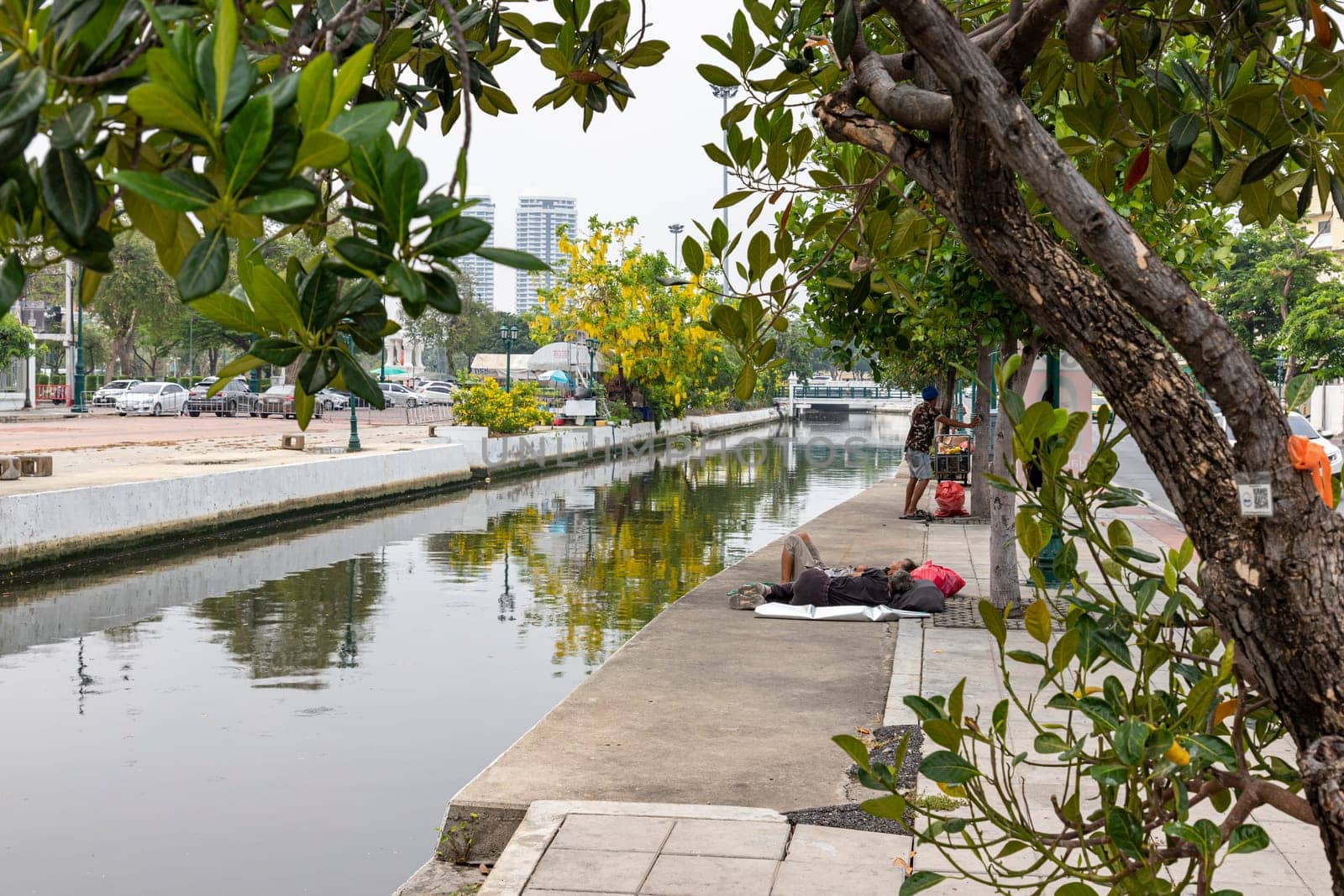 Bangkok,Thailand - April 16, 2023: If coming to Bangkok, you will be able to see homeless people resting on the sidewalks along the Khlong Lot. in front of Rattanakosin Hotel, Ratchadamnoen Road