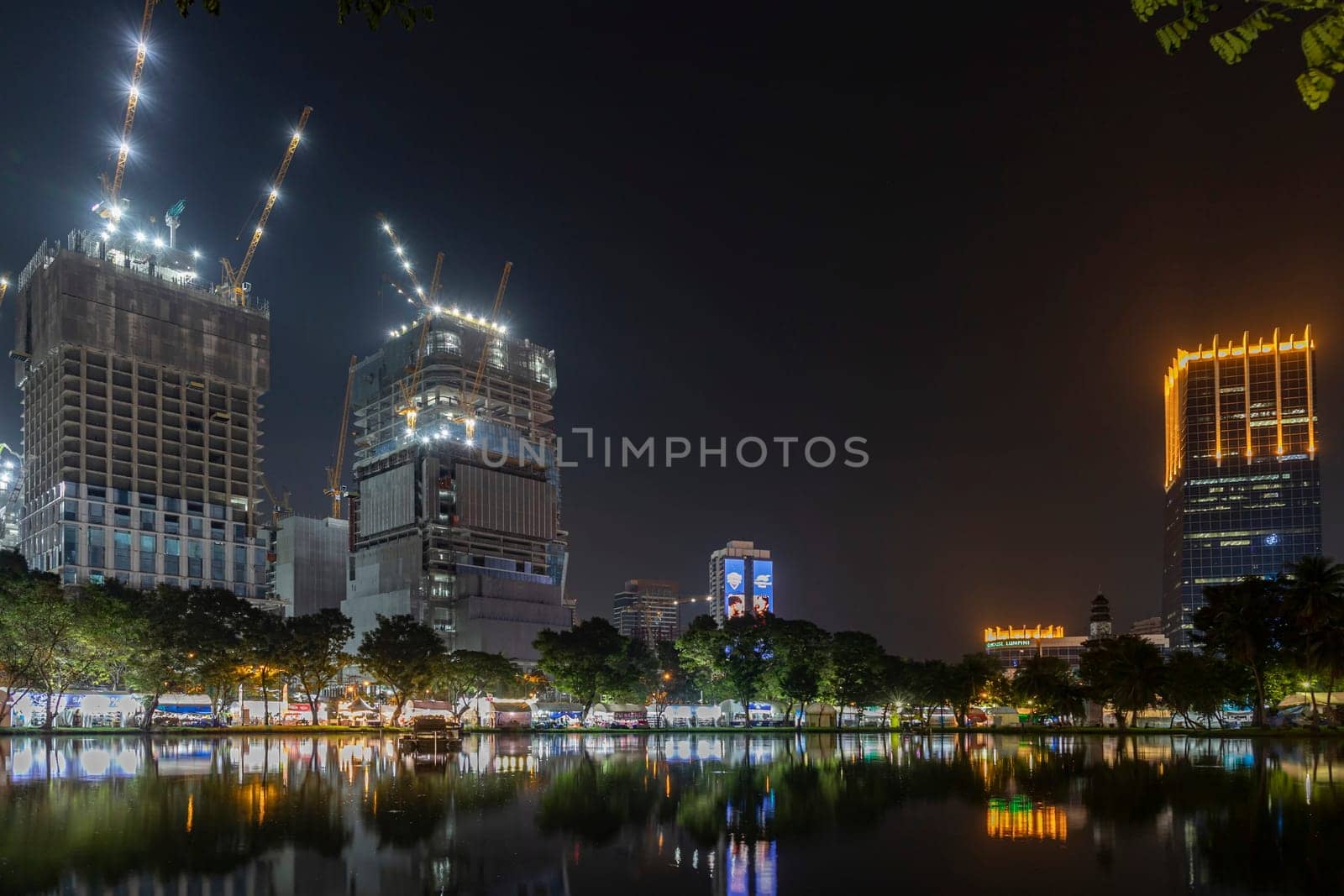 Bangkok, Thailand - Dec 8, 2022:Waterfront view of Lumpini Park at night on the day of the Red Cross Fair Causing there to be lights along the riverside path beautiful atmosphere Between 8-18 Dec 2022
